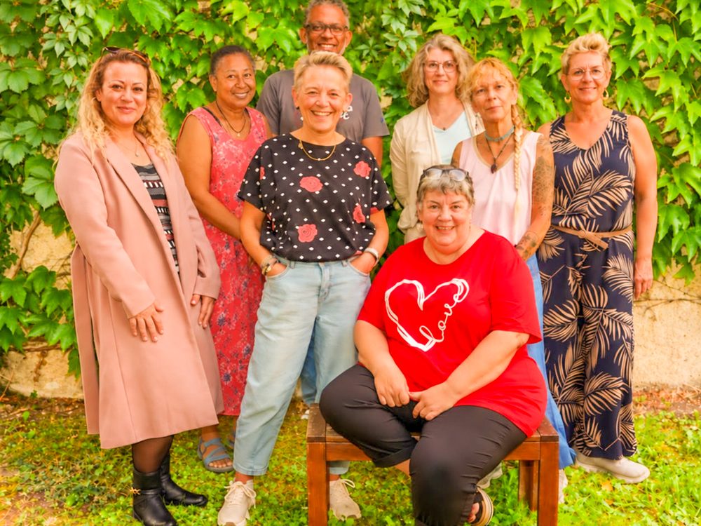 Les membres de l'association réunis devant un mur de vigne vierge.