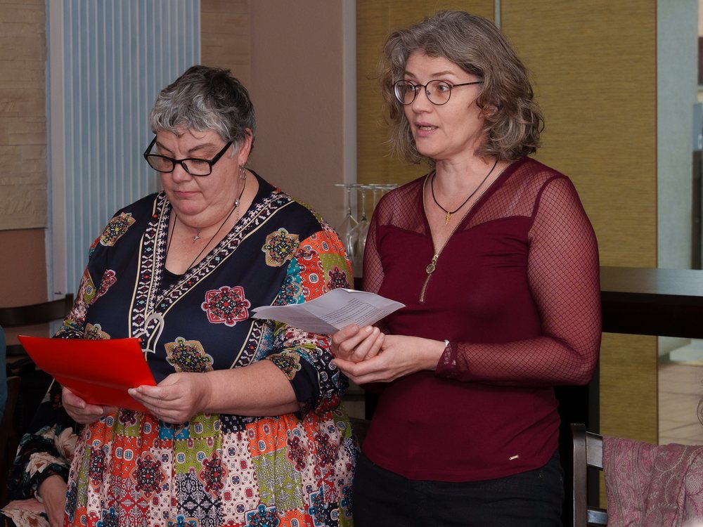 Deux membres de l'association lisent un texte, feuilles en main.